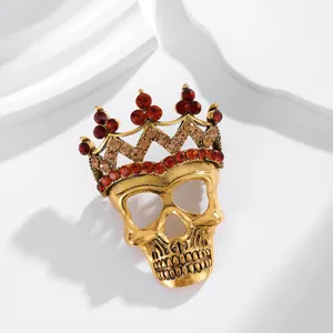 Detailed view of a vintage gold Halloween skull brooch with a rhinestone crown.