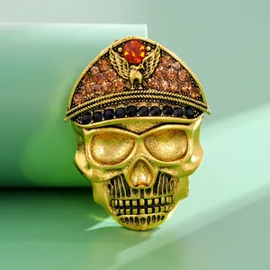 Vintage Halloween skull brooch with rhinestones and military hat on green background