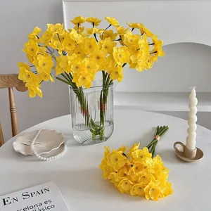 Elegant artificial yellow narcissus flower bouquet displayed in a ribbed glass vase