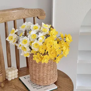 Detailed view of artificial white and yellow narcissus flowers in a woven basket