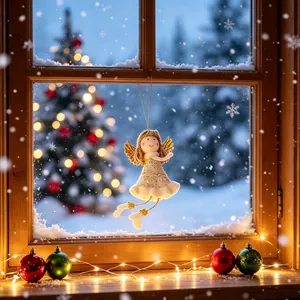 Handgemaakte kerstengel hanger in een besneeuwd venster met feestelijke verlichting