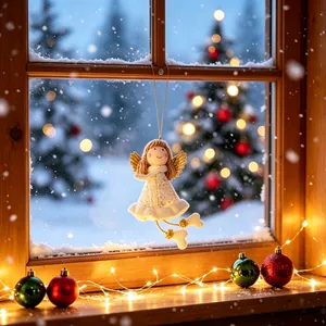 Detailweergave van een handgemaakte kerstengel die aan een koud besneeuwd raam hangt