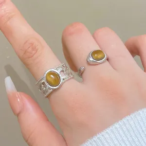Detailed view of silver-tone vintage tiger eye stone rings worn on female fingers