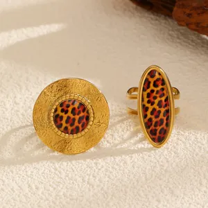 Detailed view of two vintage leopard print gold rings on a textured surface