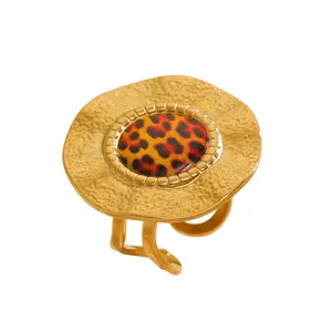 Macro detail of a gold textured ring featuring a bold leopard print center inlay.