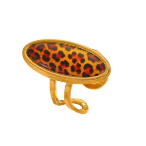 Macro view of a gold-plated ring featuring a glossy leopard print oval centerpiece