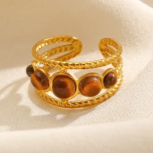 Close-up detail of a gold-toned adjustable multi-layer ring featuring brown tiger eye stones