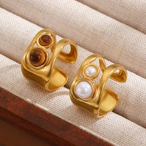 Detailed macro view of vintage style gold open rings with tiger eye and pearl inlay decoration
