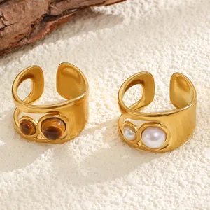 Detailed macro view of vintage matte gold rings set with tiger eye stones and white pearls