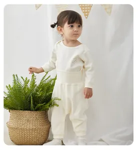 Toddler wearing a cream white organic cotton thermal underwear set in a cozy home setting