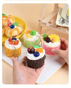 Detailed close-up of realistic PU mousse cake keychains with faux fruit and cream