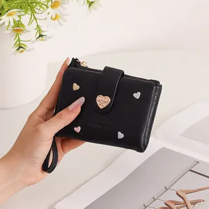 Close-up of elegant black bifold wallet with colorful heart embroidery and gold clasp