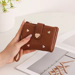 Close-up of brown women's short wallet with heart embroidery and heart buckle detail