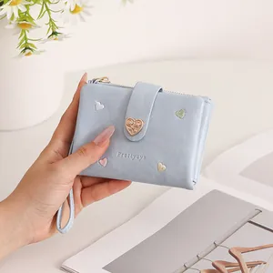 Detailed view of light blue heart-embroidered folding wallet with zip and strap