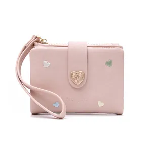 Close-up view of the pink faux leather wallet featuring embroidered hearts and a rose buckle