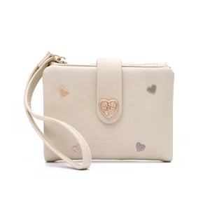 Close-up of cream women's short wallet with heart embroidery and buckle detail