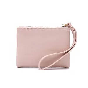 Detail view of a soft pink pebbled faux leather women's coin pouch with a wrist strap