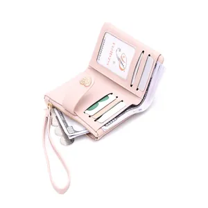 Detail view of pink leather short wallet showing interior card slots and heart buckle