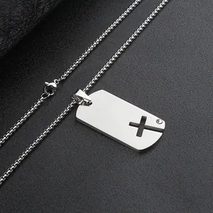 Close-up detail of a minimalist stainless steel dog tag pendant with a hollow cross