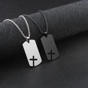Detail view of black and silver stainless steel dog tag necklaces with cross cutouts.