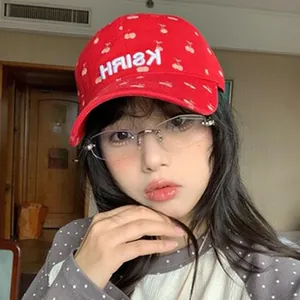Detailed view of a model wearing a red retro American style baseball cap with cherries