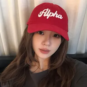 Red American vintage soft-top baseball cap with white Alpha embroidery worn by a model