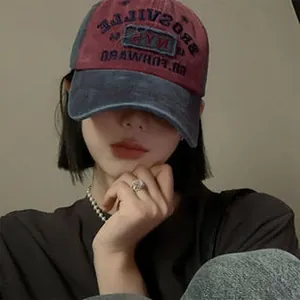 Close-up of a vintage washed denim baseball cap worn by a model in a soft-lit studio setting