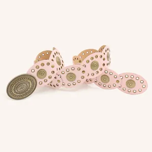 Detailed view of a stylish pink bohemian link belt with an ornate bronze buckle.