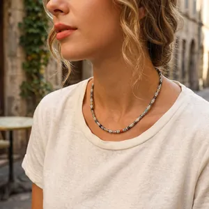 Vista dettagliata di una collana di perle di pietre semipreziose indossata da donna.