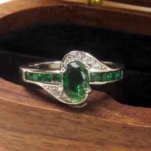 Luxury silver rotatable ring featuring a central oval green zirconia and pavé stones