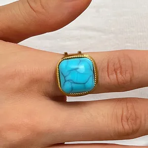 Detailed close-up of a vintage bohemian ring with a square turquoise gemstone.