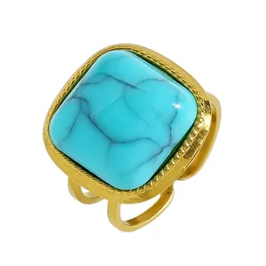 Detail of vintage bohemian ring featuring a square turquoise stone in a gold setting