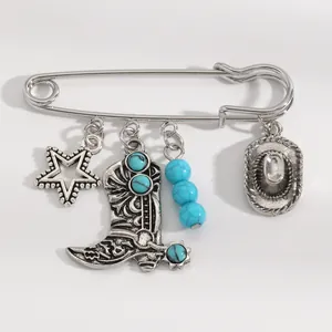 Vue détaillée d'une broche de style cowboy western avec des breloques turquoise et bottes