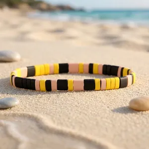 Detailed view of a candy-colored tile beaded stretch bracelet on a sunny beach