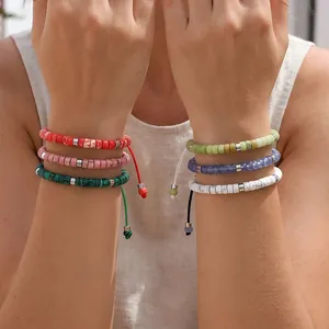 Detail van kleurrijke handgemaakte armbanden van natuurlijke halfedelstenen om de polsen.
