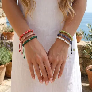 Detailweergave van handgemaakte geweven armbanden van halfedelstenen op een vrouwelijk model