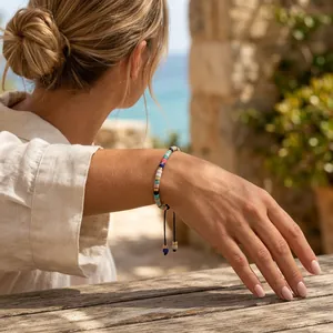 Detail van een handgemaakte armband van kleurrijke halfedelstenen om een pols van