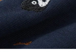 Detailed macro view of navy blue knitted fabric with character embroidery for kids suit.