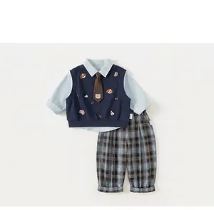 Detail of boys' gentleman suit set with shirt, animal pattern vest, and plaid pants.