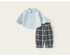 Detailed flat lay of boys light blue shirt and blue plaid trousers outfit set