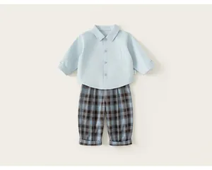 Close-up of boy's gentleman suit set featuring light blue shirt and plaid trousers