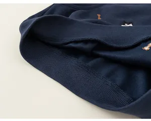 Detailed macro shot of navy blue boy's sweatshirt featuring ribbed hem and cute embroidery