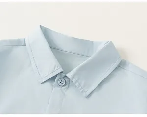 Detail view of light blue boy's shirt collar with fine stitching and visible button