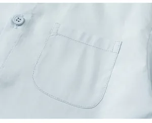 Close-up detail of a light blue boys' shirt pocket with fine stitching and button