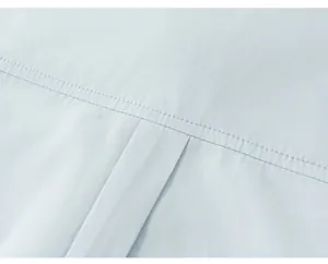 Macro detail showing the high-quality yoke stitching on a boys' light blue dress shirt