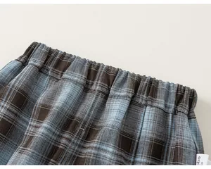 Close-up view of the elastic waistband and blue plaid fabric texture on children's trousers