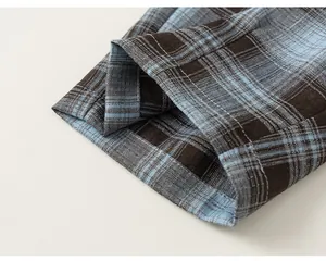 Macro close-up detail showing the blue and brown plaid fabric texture of boy's trousers