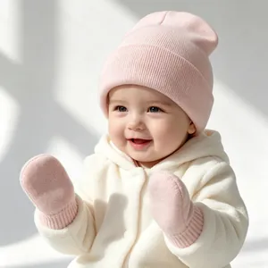 Infant wearing a soft pink knitted beanie and matching mittens in a cozy winter scene