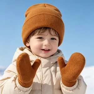 Close-up of a smiling toddler wearing a warm ginger knit hat and matching mittens