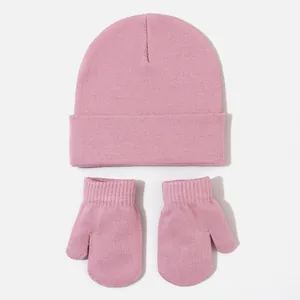 Detail view showing a soft pink knitted baby beanie and matching mitten set for winter